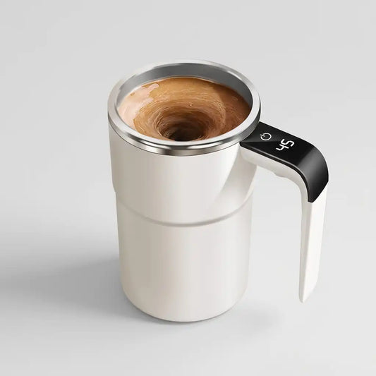A white insulated travel mug with a black digital handle and stainless steel rim, filled with a swirling latte or coffee drink, shown on a light gray background.
