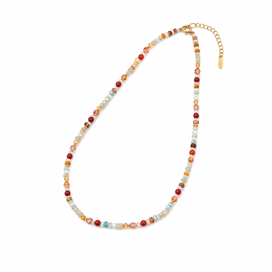 A beaded necklace with small multicolored beads in red, orange, yellow, white, and light blue, accented with gold-toned metal links and an extender chain, shown on a plain white background.